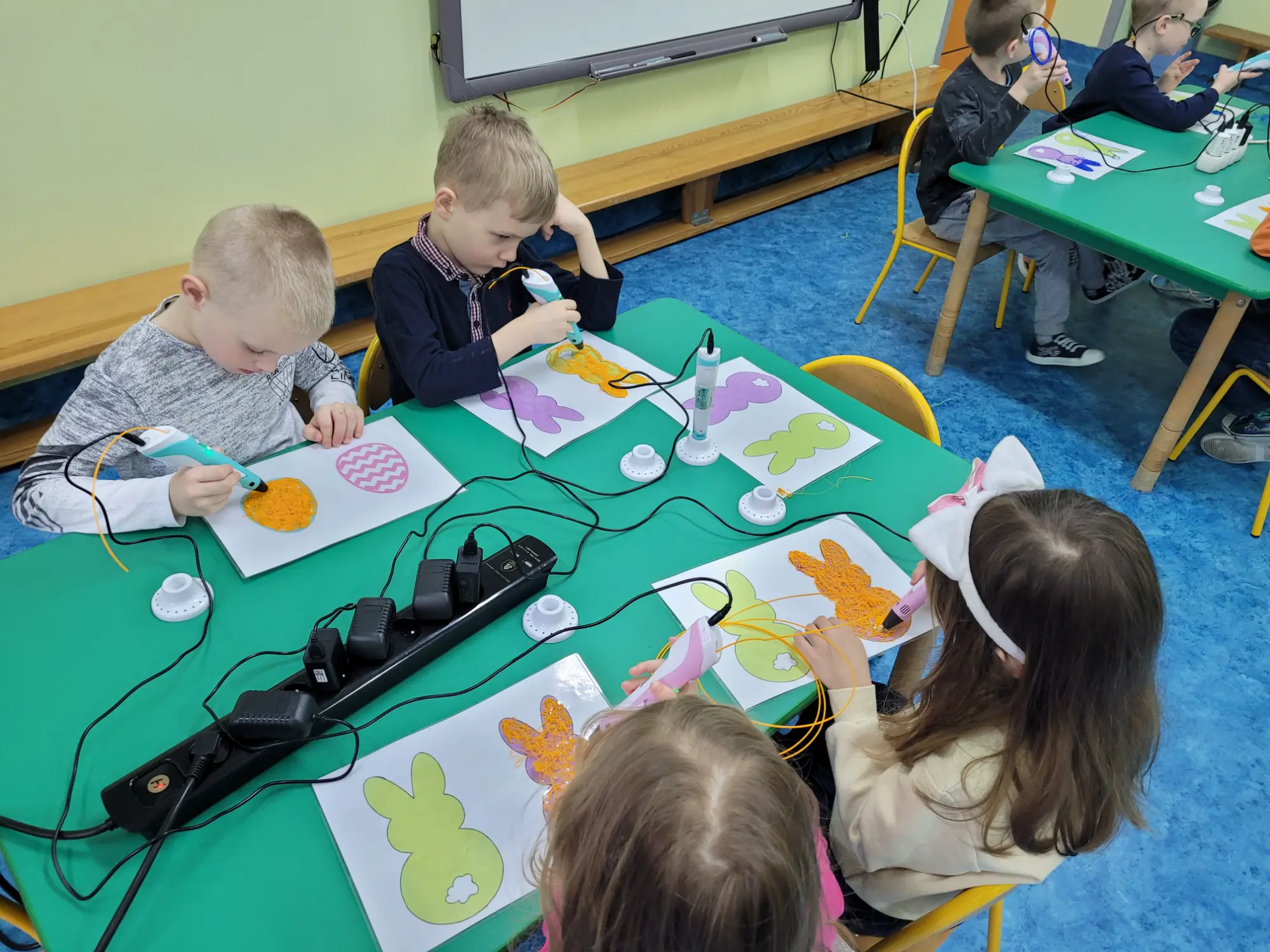 Przedszkolaki wypełniają szablony zajączków długopisami 3D