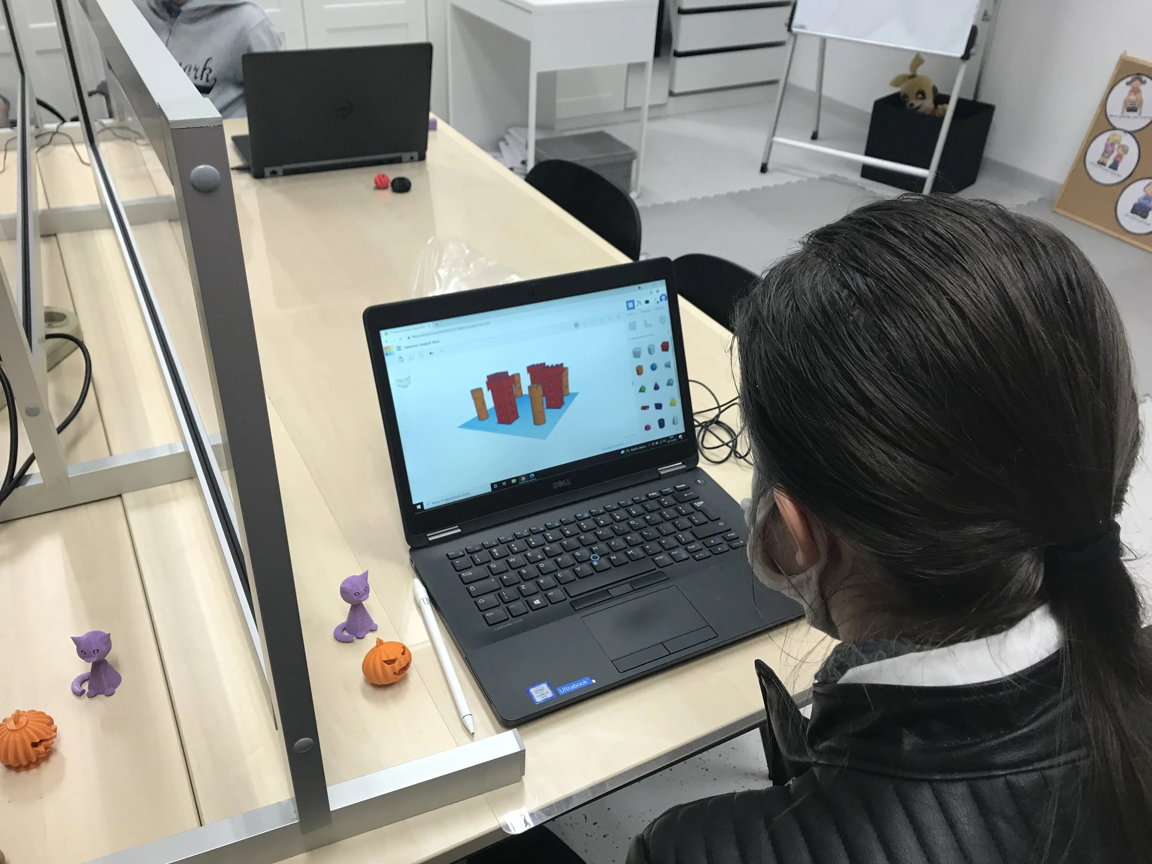 Uczennica modeluje figurkę w programie do projektowania 3D