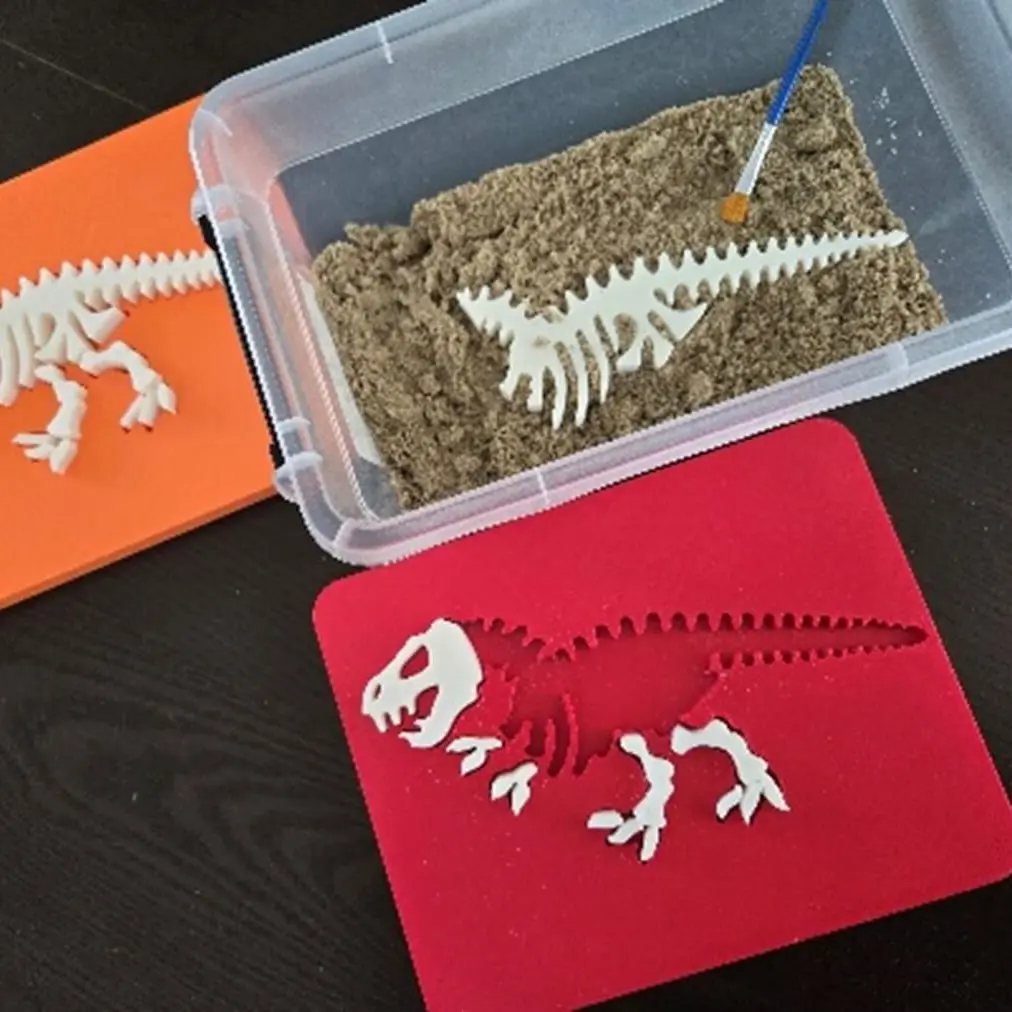 Wydrukowane w 3D szkielety dinozaurów w pudełku z piaskiem