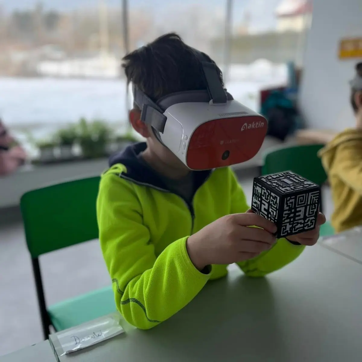 Chłopiec w goglach VR trzyma kostkę z markerem