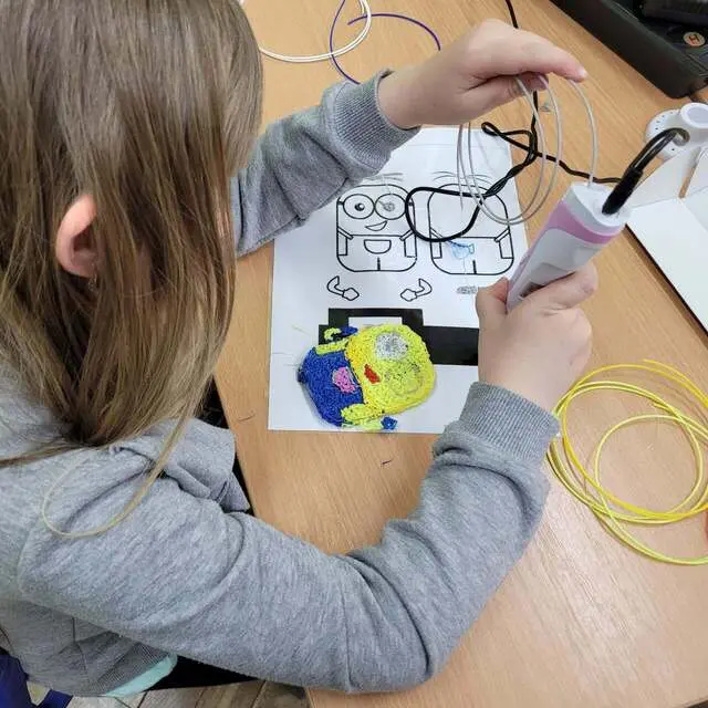 Dziewczynka rysuje długopisem 3D po szablonie