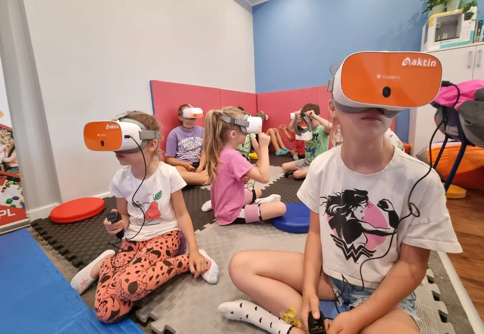 Dzieci w goglach VR podczas zajęć na macie