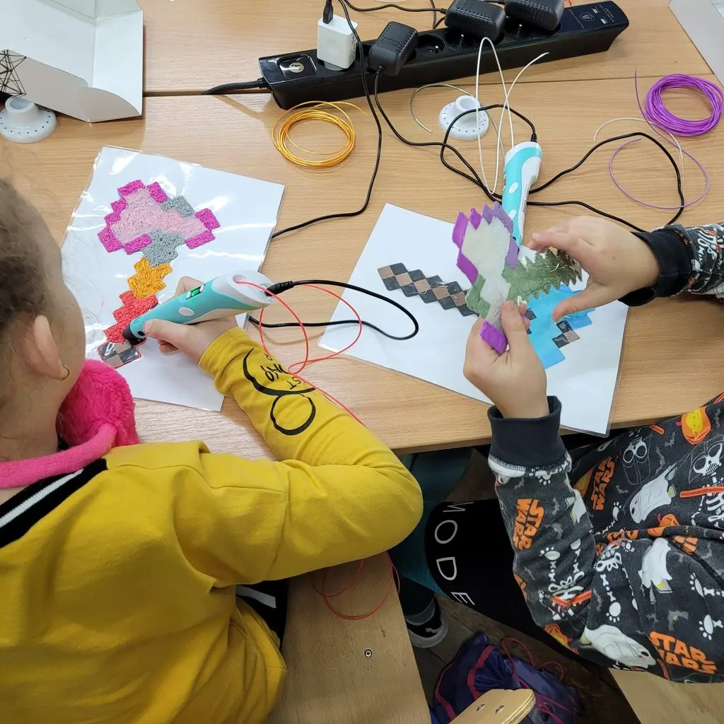 Kolorowe prace wykonane długopisami 3D na stole